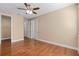 Hardwood floor bedroom with ceiling fan and walk-in closet at 8324 Vivaro Isle Way, Windermere, FL 34786