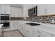 Modern kitchen with white cabinets, quartz countertops, and gas cooktop at 8324 Vivaro Isle Way, Windermere, FL 34786