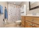 Clean bathroom with shower/tub combo, wood vanity, and seashell-themed curtain at 109 Wynot Way, Deland, FL 32724