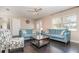 Living area with two blue sofas, dark hardwood floors, and patterned armchairs at 109 Wynot Way, Deland, FL 32724