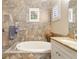 Bathroom features a large soaking tub, granite vanity, and tile surround at 11748 Waterstone Loop Dr, Windermere, FL 34786