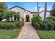 Mediterranean-style home with tile roof, lush landscaping, and a brick walkway at 11748 Waterstone Loop Dr, Windermere, FL 34786