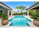 Luxury pool with spa, surrounded by lush landscaping and large planters at 11748 Waterstone Loop Dr, Windermere, FL 34786