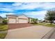 House exterior with three-car garage and brick driveway at 121 Whirlaway Dr, Davenport, FL 33837