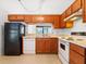 Galley kitchen with wood cabinets and appliances at 1360 Cherrybark Rd, Apopka, FL 32703