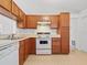 Kitchen with wood cabinets and white appliances at 1360 Cherrybark Rd, Apopka, FL 32703