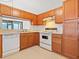 View of kitchen with wood cabinets and white appliances at 1360 Cherrybark Rd, Apopka, FL 32703