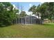 Screened-in pool area with surrounding lush trees at 1365 Indian Rock Ct, Deltona, FL 32725