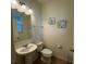 Small bathroom with pedestal sink, toilet and framed art at 13731 Bravante Aly, Windermere, FL 34786