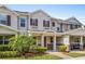 Charming two-story townhome with well-manicured landscaping and a covered front porch with chairs at 13731 Bravante Aly, Windermere, FL 34786