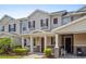 Charming two-story townhome with well-manicured landscaping, a covered front porch, and dark brown shutters at 13731 Bravante Aly, Windermere, FL 34786
