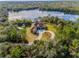 Beautiful aerial view of a lakefront home featuring a circular driveway and lush green surroundings at 1851 Grand Keahl Ln, Deltona, FL 32738