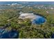 Stunning aerial view showcasing a private lakefront estate nestled amongst lush trees and a sparkling lake at 1851 Grand Keahl Ln, Deltona, FL 32738