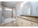 Bathroom features a granite countertop, a tub and shower, and a decorative mirror at 1851 Grand Keahl Ln, Deltona, FL 32738