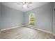 Empty bedroom with laminate flooring, a ceiling fan, and a window view of the outside at 1851 Grand Keahl Ln, Deltona, FL 32738