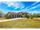 Charming home with a three-car garage, a well-manicured lawn, and beautiful landscaping at 1851 Grand Keahl Ln, Deltona, FL 32738