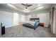 Spacious bedroom featuring gray carpet, a ceiling fan, and a gray upholstered headboard at 1851 Grand Keahl Ln, Deltona, FL 32738