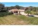 Aerial view of property featuring manicured lawn, desert landscaping, and an attached three-car garage at 38207 Sabal Way, Umatilla, FL 32784