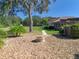 View of backyard with fire pit, lush trees, and well-maintained lawn at 38207 Sabal Way, Umatilla, FL 32784