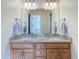 Bathroom featuring double sink vanity with granite countertop and wood cabinets at 38207 Sabal Way, Umatilla, FL 32784