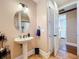 Bathroom with a pedestal sink, decorative mirror, and tiled floors at 38207 Sabal Way, Umatilla, FL 32784