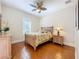 Bedroom featuring a tropically styled ceiling fan, wood floors, and a tropical themed comforter at 38207 Sabal Way, Umatilla, FL 32784