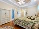 Bedroom with a floral bedspread, hardwood floors, and a tropically styled ceiling fan at 38207 Sabal Way, Umatilla, FL 32784