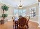 Bright dining room with a chandelier, plantation shutters, and views of the backyard at 38207 Sabal Way, Umatilla, FL 32784