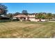 View of front yard with lush lawn, mature trees, and desert-themed landscaping at 38207 Sabal Way, Umatilla, FL 32784