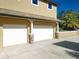 Three car garage with decorative stone pillars on a well manicured lawn and garden at 38207 Sabal Way, Umatilla, FL 32784