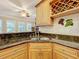 Close-up of the kitchen sink, which features wood cabinets and a dark countertop at 38207 Sabal Way, Umatilla, FL 32784