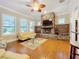 Bright living room featuring a stone fireplace, wood floors, and a stylish ceiling fan at 38207 Sabal Way, Umatilla, FL 32784