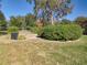 View of landscaped yard featuring well-maintained lawn, trimmed bushes, and decorative rocks at 38207 Sabal Way, Umatilla, FL 32784