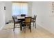 Minimalist dining area with a dark wood table, chairs, and tile flooring at 5093 Meadow Song Dr, Okahumpka, FL 34762