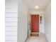 Front entry with coral door, welcome mat and white walls at 5132 Lazy Oaks Dr # 5132, Winter Park, FL 32792