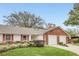 Exterior view of a two-unit home with a double garage and well-maintained landscaping at 5132 Lazy Oaks Dr # 5132, Winter Park, FL 32792