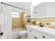 Updated bathroom with yellow tile, white vanity, and bathtub at 528 Broadway Ave, Orlando, FL 32803