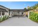 Open carport with white pillars, complemented by lush landscaping and an EV charger for modern convenience at 528 Broadway Ave, Orlando, FL 32803