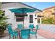 Inviting front patio with teal table, chairs, and umbrella at 528 Broadway Ave, Orlando, FL 32803