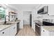 Well-lit kitchen featuring white cabinets, stainless steel appliances, and granite countertops at 528 Broadway Ave, Orlando, FL 32803