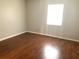 Simple bedroom with wood-look floors and single window at 5429 Vineland Rd # S, Orlando, FL 32811