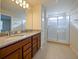 Bathroom with shower, double vanity, and granite countertop at 5650 Wooden Pine Dr, Orlando, FL 32829