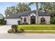 Tan one-story house with a gray roof, palm tree, and manicured lawn at 623 Yorkshire Dr, Oviedo, FL 32765