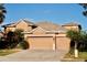 Two-story house with a three-car garage and landscaping at 6879 Remington View Ct, Orlando, FL 32829