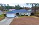 One-story house with a blue roof, white garage door, and landscaped front yard at 6928 Sw 152Nd St, Ocala, FL 34473