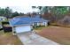 One-story house with blue roof, white garage door, and neatly landscaped yard at 6928 Sw 152Nd St, Ocala, FL 34473