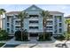 Exterior of a multi-story building with tropical landscaping, balconies, and convenient parking in front at 7618 Sandy Ridge Dr # 103, Reunion, FL 34747