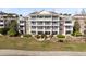 Exterior view of a multi-level building with balconies and manicured landscaping, highlighting outdoor living at 7618 Sandy Ridge Dr # 103, Reunion, FL 34747