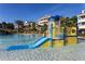 Vibrant community pool featuring a blue and yellow slide and a water bucket feature for Gathering fun at 7618 Sandy Ridge Dr # 103, Reunion, FL 34747