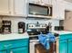 Stainless steel range and microwave in teal kitchen at 7654 Comrow St # 101, Kissimmee, FL 34747